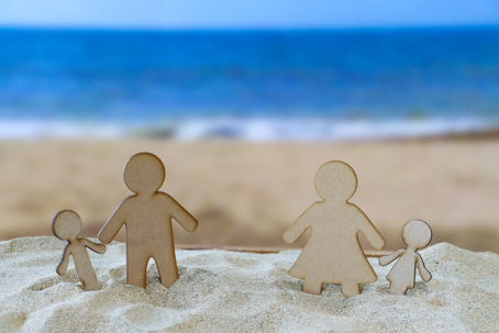 wooden figures of a family on a beach