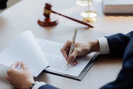 Lawyer signing a document on his desk